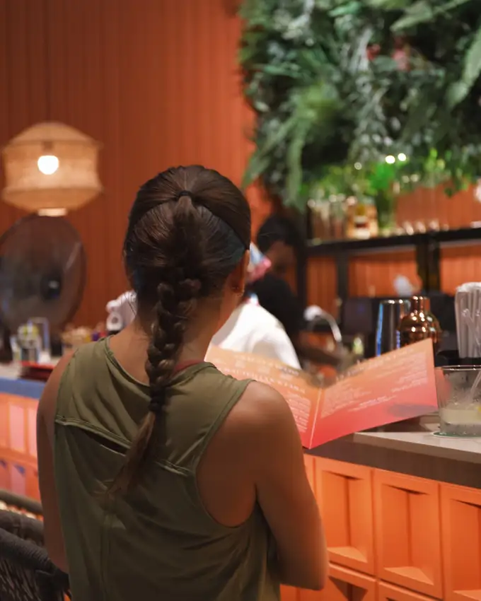 A guest at Crafty's warm, plant-filled bar
