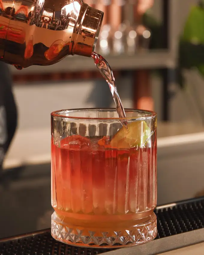 A cocktail being poured over ice at Crafty's
